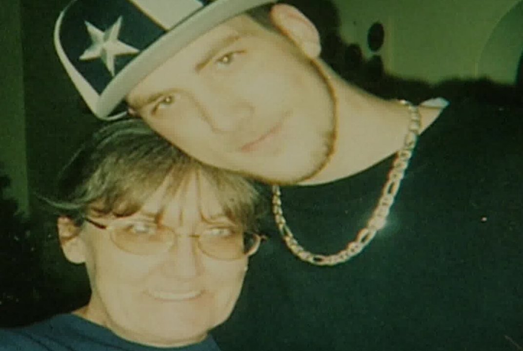 Daniel in a star cap resting his head on top of his mom Becky's head, both smiling